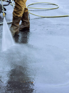 Using pressurized water to clean street, wet washing roadway