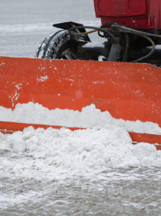Tractor cleaning the road from the snow. Excavator cleans the streets of large amounts of snow in city.